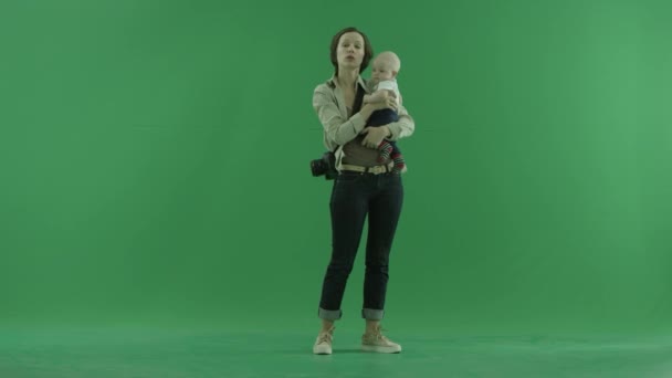 Una joven está hablando con su bebé en la pantalla verde — Vídeos de Stock