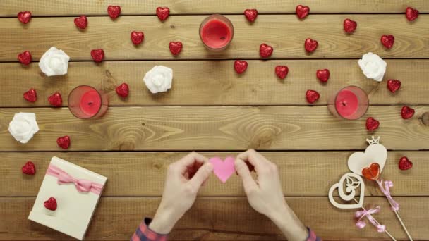 Kreativní člověk s ručně dělané srdcem papíru sedí u stolu, pohled shora — Stock video