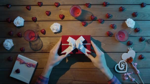 L'uomo mette San Valentino sulla scatola regalo per la sua ragazza, vista dall'alto — Video Stock