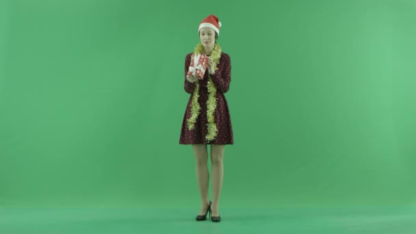 Egy fiatal nő keres egy karácsonyi ajándék, a zöld képernyőn — Stock videók