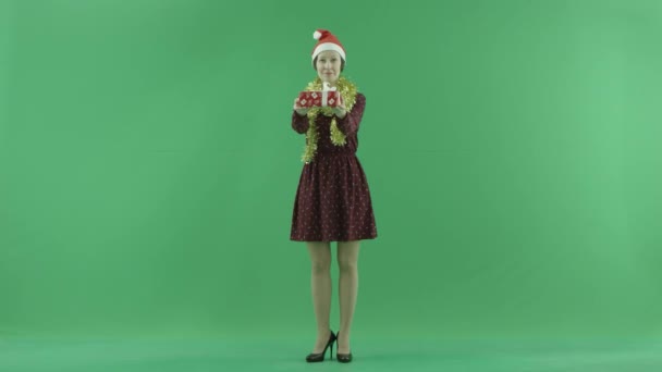 若い女性は緑色の画面で視聴者のためのクリスマス プレゼントを与えています。 — ストック動画