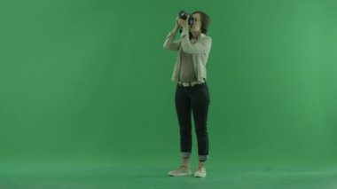 Genç bir kadın fotoğrafları üst'sol tarafında yeşil ekranda alıyor