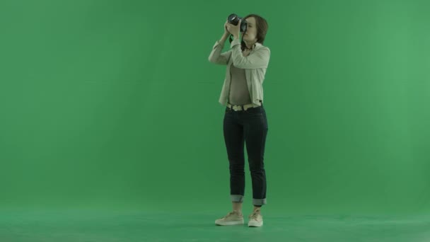 一个年轻的女人在绿色屏幕上自己的左手边拍照 — 图库视频影像