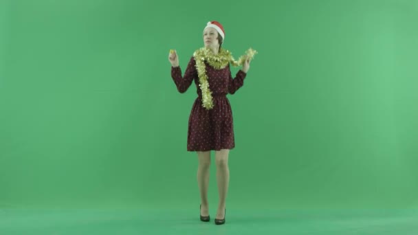 Eine junge Frau tanzt zur Zuschauerseite in der Mitte des grünen Bildschirms — Stockvideo