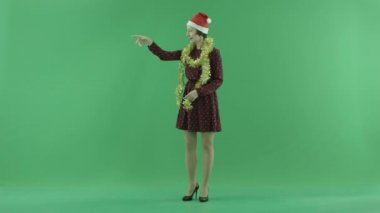 Genç bir Noel kadın birisi için yeşil ekranda sol taraftan aramalar