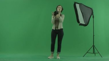 Bir genç kadın alarak fotoğraf yeşil bir görüntüleyicinin ekran ve onun ayakta düzeltmek