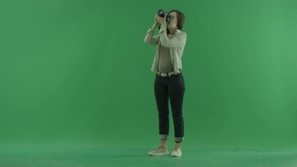 若い女性は緑色の画面に左手側に彼女自身の写真上を取っています。 — ストック動画