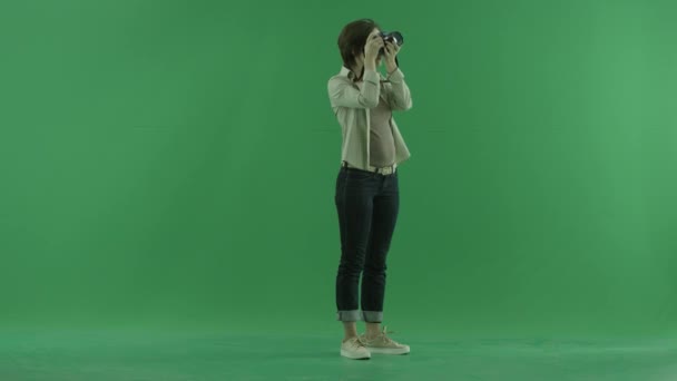 Uma jovem está tirando fotos acima de si mesma no lado direito na tela verde — Vídeo de Stock