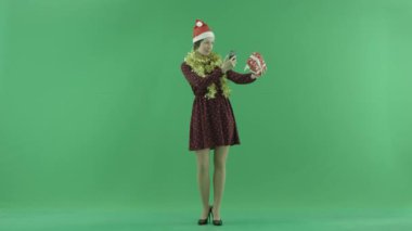 Genç bir kadın yeşil ekranda Noel hediyesini fotoğrafını çekmek