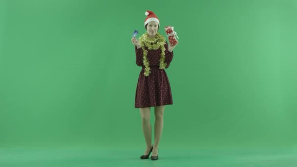 Egy fiatal nő mutatja a néző egy hitelkártya a vásárlás karácsonyi ajándék a zöld képernyőn — Stock videók