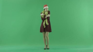 Genç bir Noel kız yeşil ekranda soğuk hissediyor