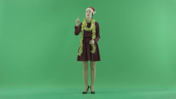 Uma jovem mulher de Natal está procurando algo em uma tela de toque grande no lado do espectador na tela verde — Vídeo de Stock