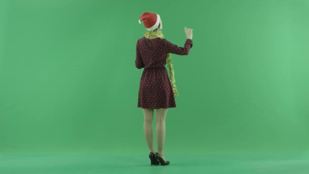 En ung jul kvinna söker efter något på en stor pekskärm på baksidan till betraktaren sida på grön skärm — Stockvideo