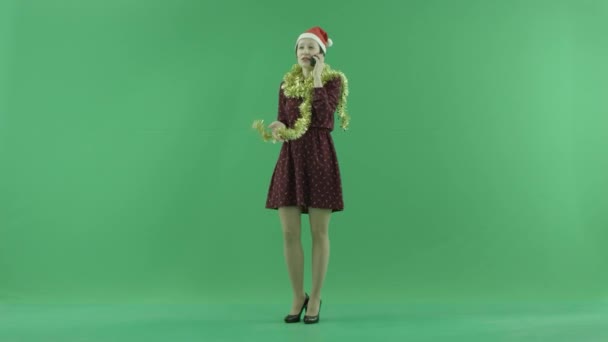 Una joven mujer de Navidad hablando en su teléfono en la pantalla verde — Vídeos de Stock
