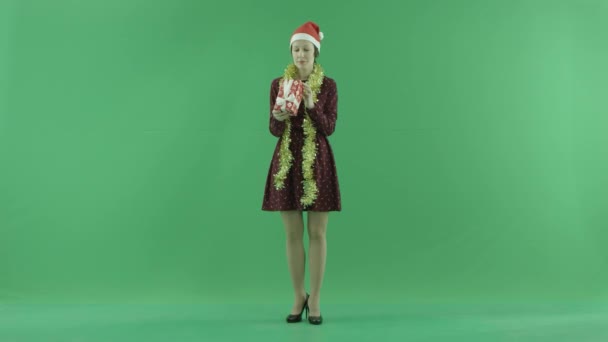 Uma jovem está à procura de um presente de Natal na tela verde — Vídeo de Stock
