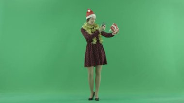 Genç bir kadın yeşil ekranda Noel hediyesini fotoğrafını çekmek