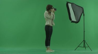 Çekici bir genç kadın, yeşil ekranda sağ tarafta fotoğraf ve ayakta bir modelinin düzeltir