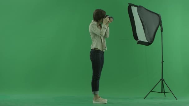 젊은 여자는 오른쪽에 녹색 화면에 사진을 찍고 — 비디오
