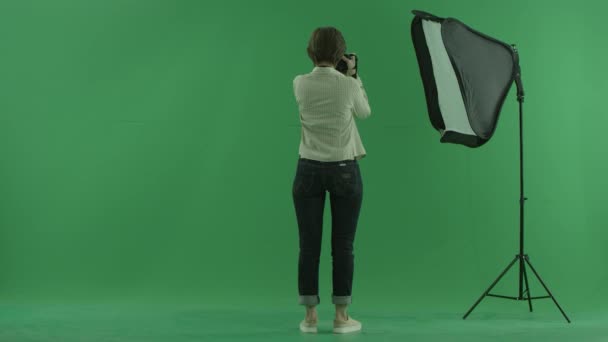 一个年轻的女人一边拍着照片边上的绿屏上的观众 — 图库视频影像