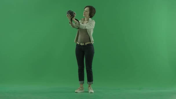 Μια νεαρή γυναίκα λήψη φωτογραφιών του εαυτού της στην μπροστινή πλευρά σχετικά με την πράσινη οθόνη — Αρχείο Βίντεο