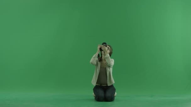 Sitter unga kvinna tar foton övre henne på grön skärm — Stockvideo