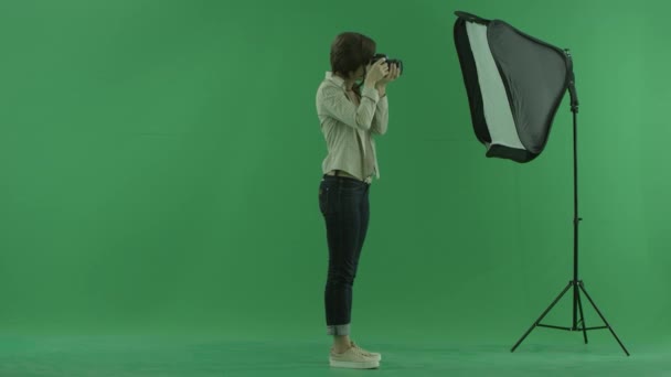 Une jeune femme prenant des photos sur le côté droit de l'écran vert — Video