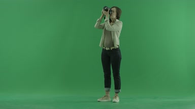 Genç bir kadın fotoğrafları üst'sol tarafında yeşil ekranda alıyor
