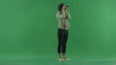 Genç bir kadın fotoğrafları üst'sağ tarafta yeşil ekranda alıyor