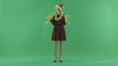 Genç bir Noel kadın yeşil ekranda etrafa