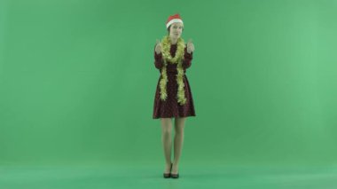 Genç bir Noel kadın yeşil ekranda serin bir şey olduğunu gösterir