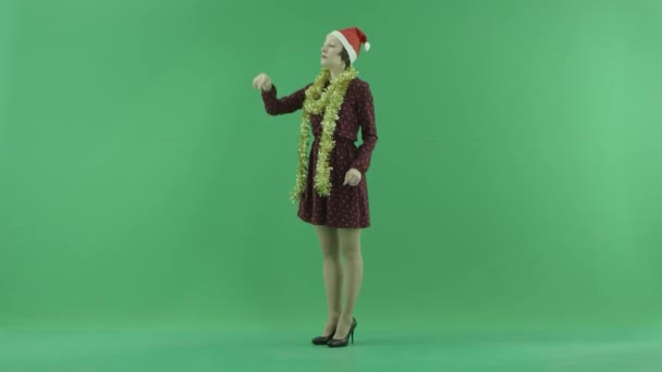 Młoda kobieta Boże Narodzenie jest szukając czegoś na duży dotykowy ekran, pół zwrócił się po lewej stronie na zielony ekran — Wideo stockowe