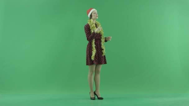 Młoda kobieta Boże Narodzenie jest szukając czegoś na duży dotykowy ekran, pół włączona po prawej stronie na zielony ekran — Wideo stockowe