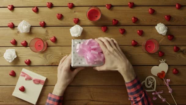 Joven hombre consigue fidget spinner juguete como regalo de San Valentín, vista superior — Vídeos de Stock