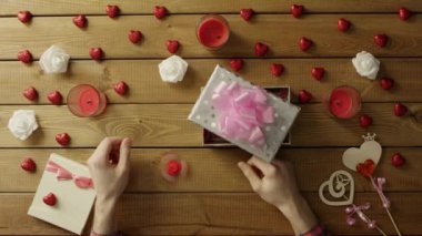 Genç adam kıpırdamak spinner hediye kutusu koyar tatil hediyesi, üst görüntüleme biçimi