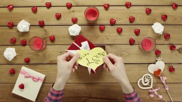 Homme met valentine en papier dans la boîte actuelle, vue du dessus — Video