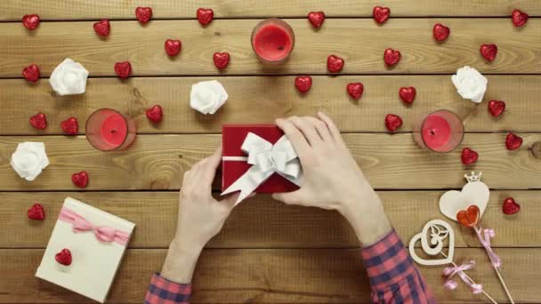 Mann bekommt Aufkleber mit Fragezeichen als Urlaubsgeschenk in Geschenkbox, Ansicht von oben — Stockvideo