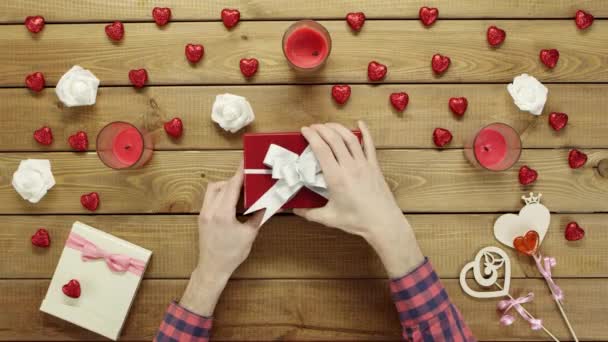 De mens krijgt creditcard als de dag van de Valentijnskaart aanwezig in de doos van de gift, bovenaanzicht — Stockvideo