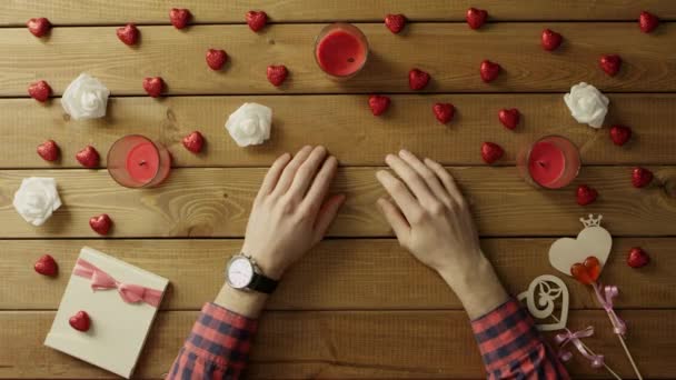 Man zit door tabel met luxe horloge op zijn hand en wacht op iets, bovenaanzicht — Stockvideo