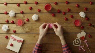 Kağıt kalp ile neşeli adam ahşap masa, üstten görünüm oturur