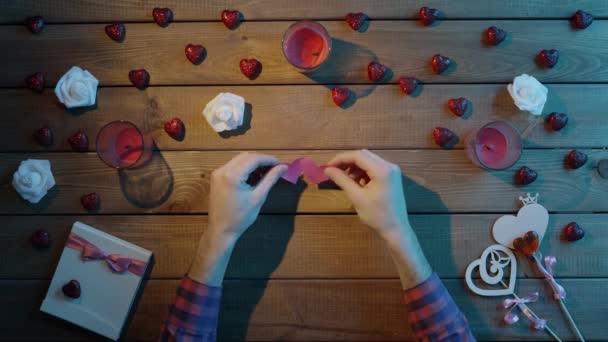 Felnőtt ember merített papír szívvel ül, fából készült tábla, felülnézet — Stock videók