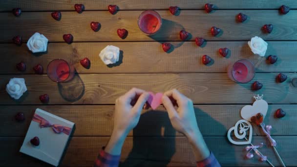 Kreatív ember papír szívvel ül, fából készült tábla, felülnézet — Stock videók