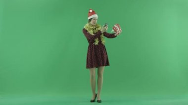 Genç bir kadın yeşil ekranda Noel hediyesini fotoğrafını çekmek