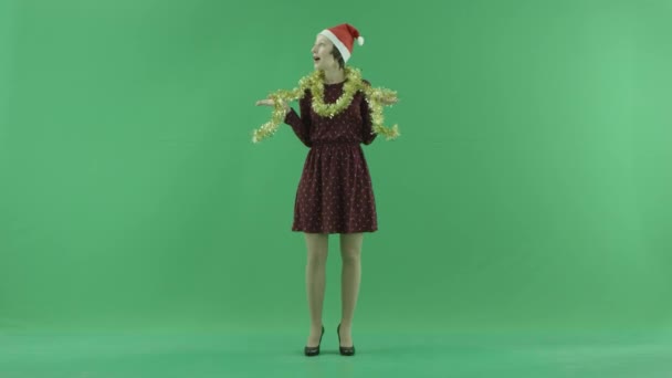 एक युवा क्रिसमस महिला ग्रीन स्क्रीन पर चारों ओर देख रही है — स्टॉक वीडियो