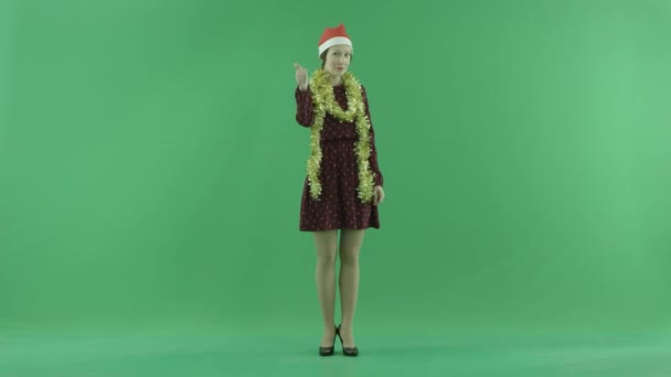 Uma jovem mulher de Natal está mostrando que algo está legal na tela verde — Vídeo de Stock