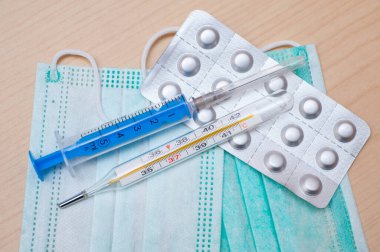 Merkür termometresi yüz maskesi, haplar ve şırıngayla yüksek sıcaklık gösteriyor.. 