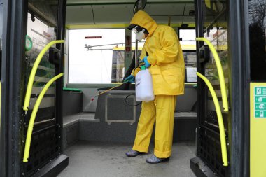 Lviv, Ukrayna, 03 Mart 2020. İşçiler otobüs durağına vardıktan sonra bir tramvayı dezenfekte ettiler. İlk Coronavirus Covid-19 vakası Ukrayna 'da doğrulandı..