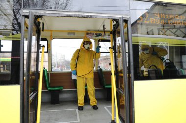 Lviv, Ukrayna, 03 Mart 2020. İşçiler otobüs durağına vardıktan sonra bir tramvayı dezenfekte ettiler. İlk Coronavirus Covid-19 vakası Ukrayna 'da doğrulandı..