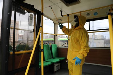 Lviv, Ukrayna, 03 Mart 2020. İşçiler otobüs durağına vardıktan sonra bir tramvayı dezenfekte ettiler. İlk Coronavirus Covid-19 vakası Ukrayna 'da doğrulandı..