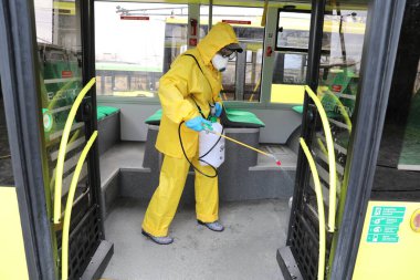 Lviv, Ukrayna, 03 Mart 2020. İşçiler otobüs durağına vardıktan sonra bir tramvayı dezenfekte ettiler. İlk Coronavirus Covid-19 vakası Ukrayna 'da doğrulandı..