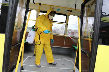 Lviv, Ukrayna, 03 Mart 2020. İşçiler otobüs durağına vardıktan sonra bir tramvayı dezenfekte ettiler. İlk Coronavirus Covid-19 vakası Ukrayna 'da doğrulandı..